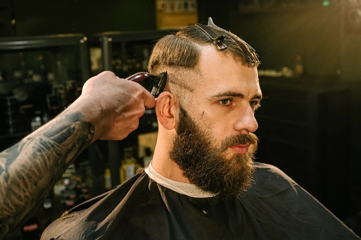 Barber fading a haircut with clippers